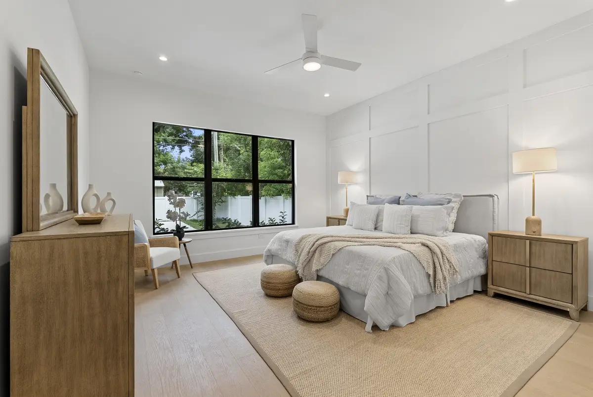 Primary bedroom with a board-and-batten accent wall and black windows